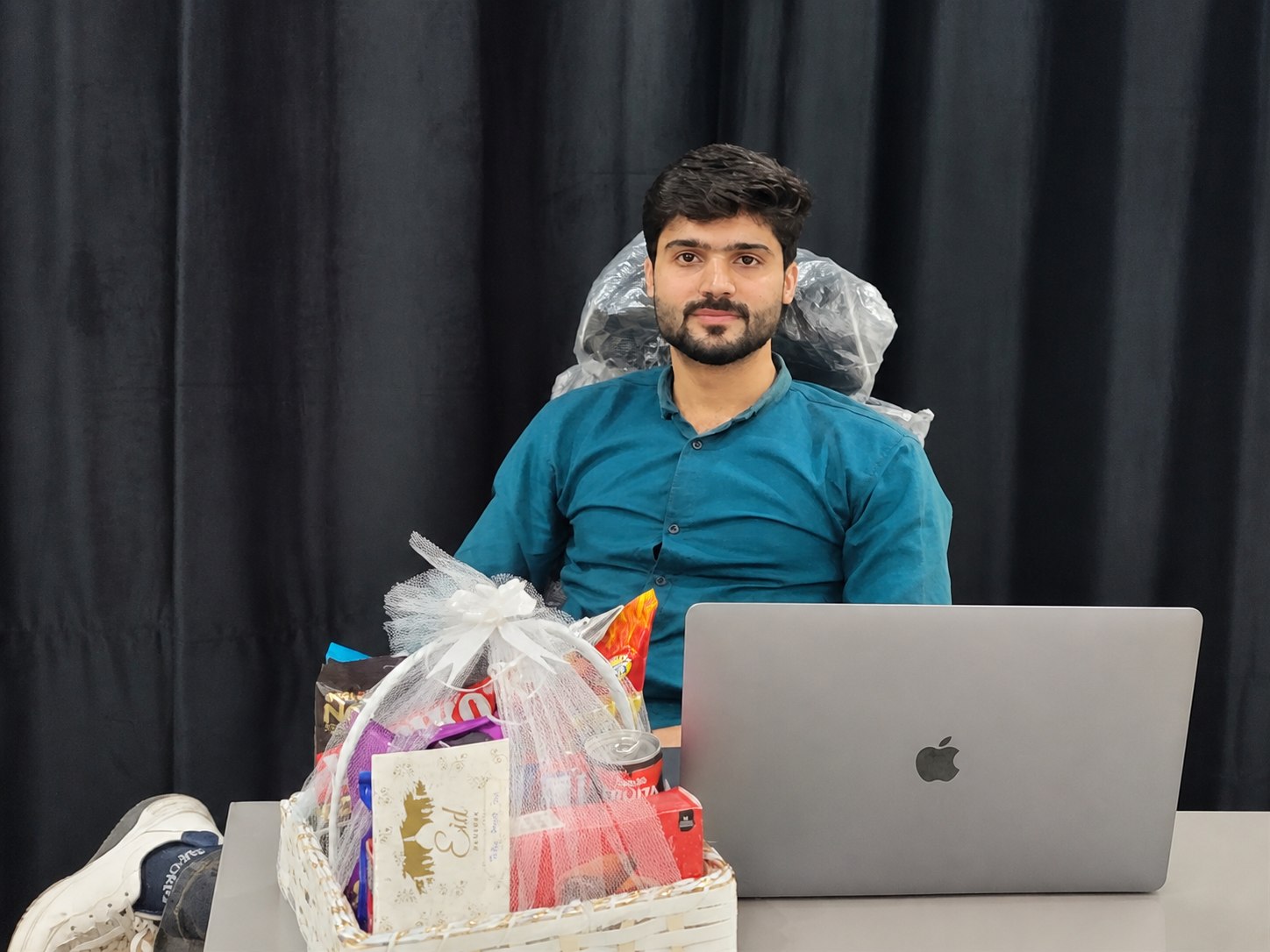 Muhammad Hamza at a company recognition moment with a laptop and appreciation gift